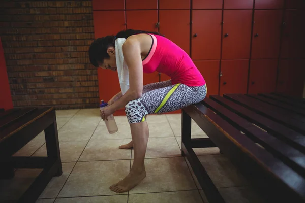 Mujer sentada en el vestuario del gimnasio — Foto de Stock