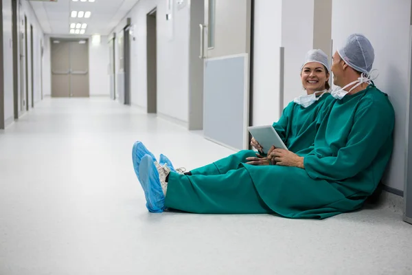 Chirurgové pomocí tabletu v chodbě — Stock fotografie