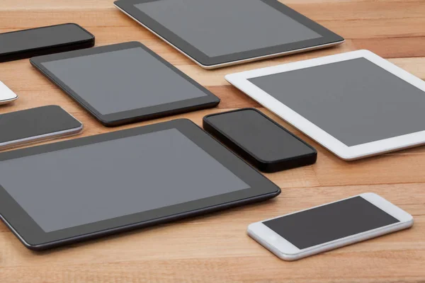 Mobiele telefoons en digitale tabletten op tafel — Stockfoto