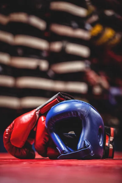 Boxing gloves and headgear in boxing ring — Stock Photo, Image