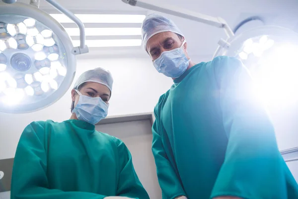 Cirurgiões realizando operação na sala de operação — Fotografia de Stock