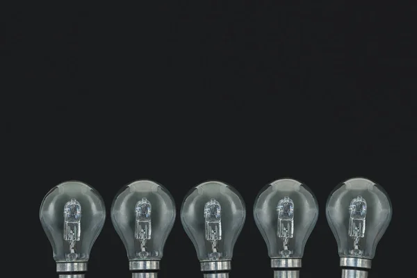 Электрические лампочки на черном фоне — стоковое фото