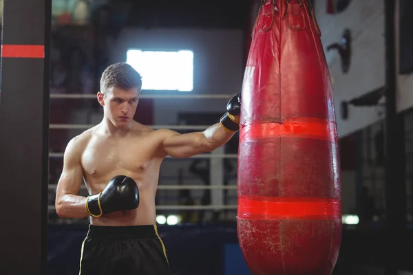 Boxer beoefenen van boksen met bokszak — Stockfoto