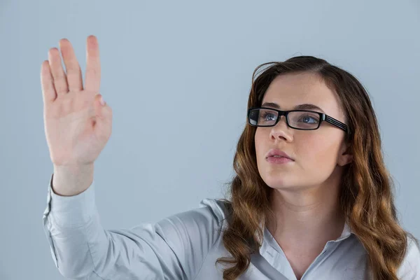 Kobieta nosi okulary, udając, że touch — Zdjęcie stockowe