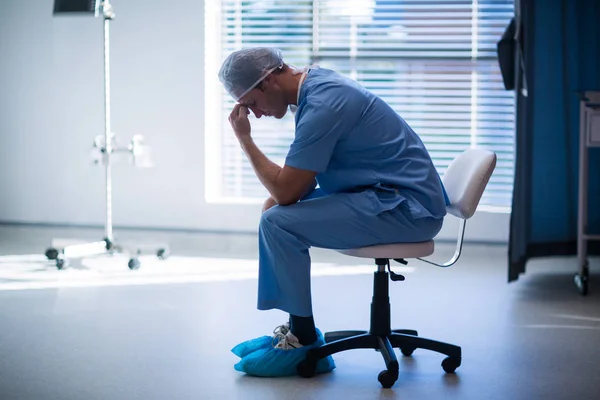복도에 앉아 긴장된 남자 간호사 — 스톡 사진