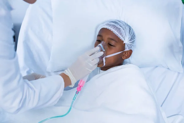 Doctor placing an oxygen mask on patient — Stock Photo, Image