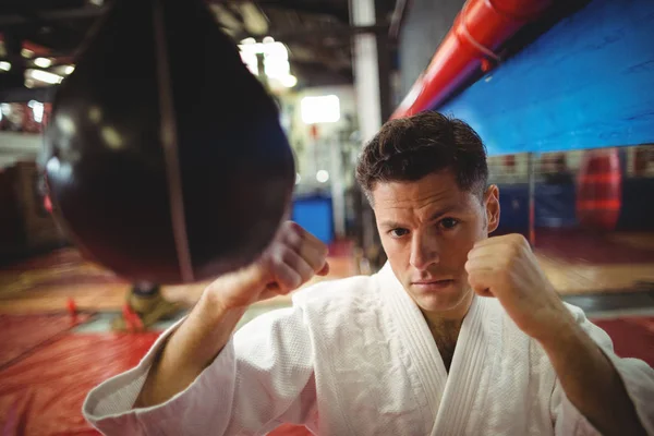 Combatiente de karate practicando karate con saco de boxeo — Foto de Stock