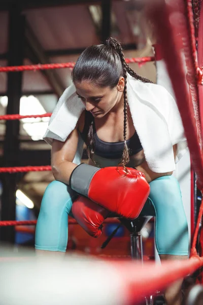Tired female boxer sitting in the ring — Stock Photo, Image