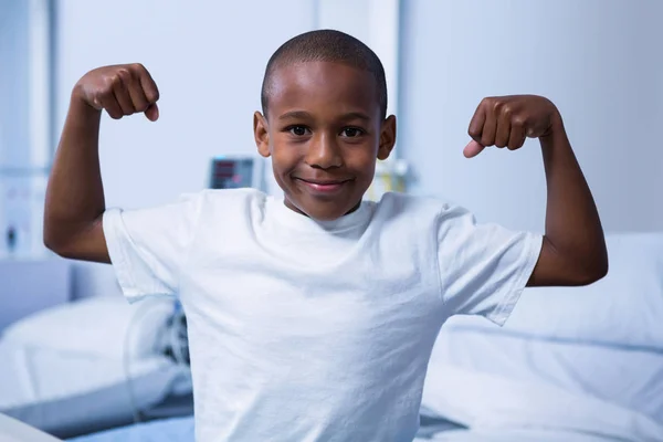 Garçon fléchissant ses muscles en salle — Photo