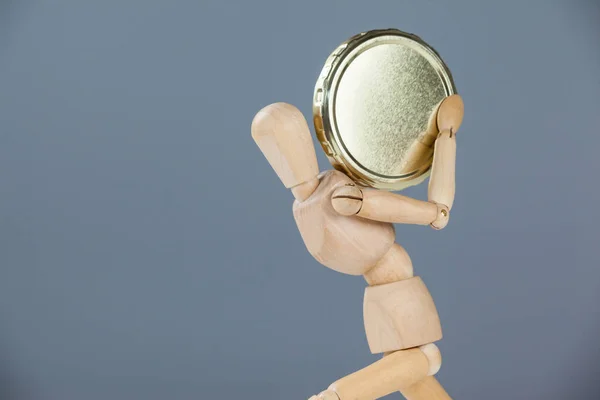 Wooden figurine holding a coin — Stock Photo, Image