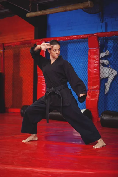 Vrouwelijke karate speler uitvoeren van karate houding — Stockfoto