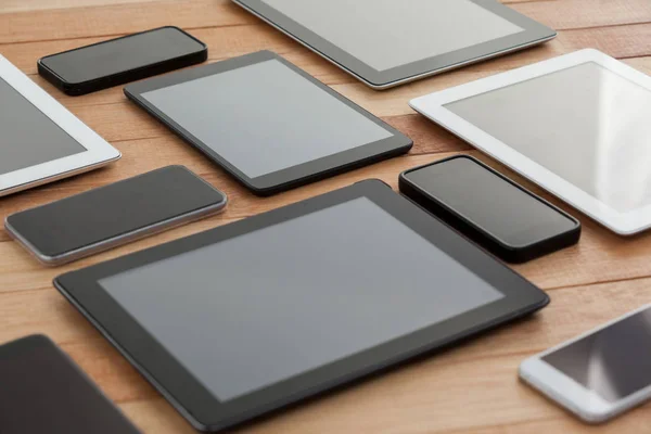 Mobiele telefoons en digitale tabletten op tafel — Stockfoto