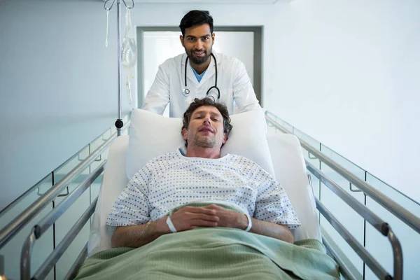 Médico empurrando cama maca de emergência — Fotografia de Stock