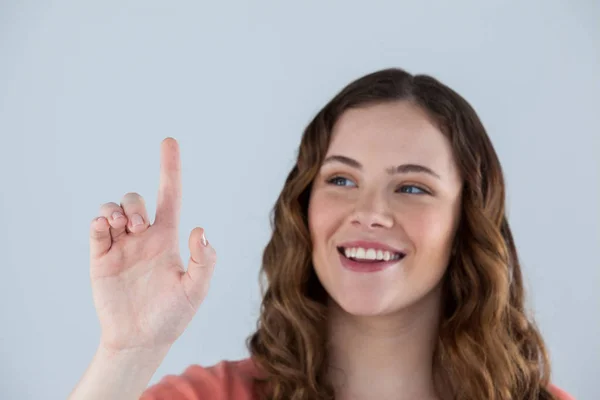 Vrouw voorwenden om een onzichtbare touchscreen — Stockfoto