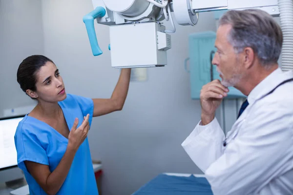 Enfermera interactuando con médico en sala de rayos X — Foto de Stock