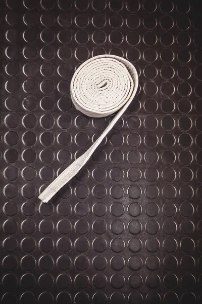 Cinturão branco de karaté sobre fundo metálico — Fotografia de Stock