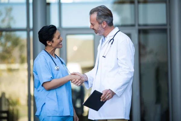 Enfermera y médico estrechando la mano — Foto de Stock