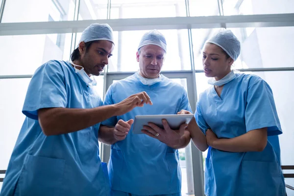 Team av kirurger diskuterar över tablett — Stockfoto