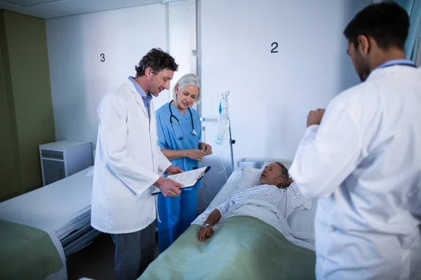 Médico e enfermeiro examinando um paciente — Fotografia de Stock