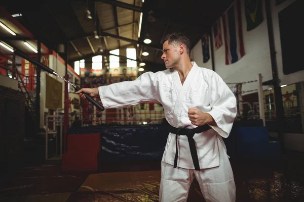Karate speler oefenen met nunchaku — Stockfoto