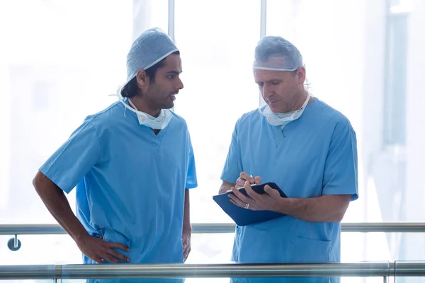 Surgeons discussing over medical reports — Stock Photo, Image