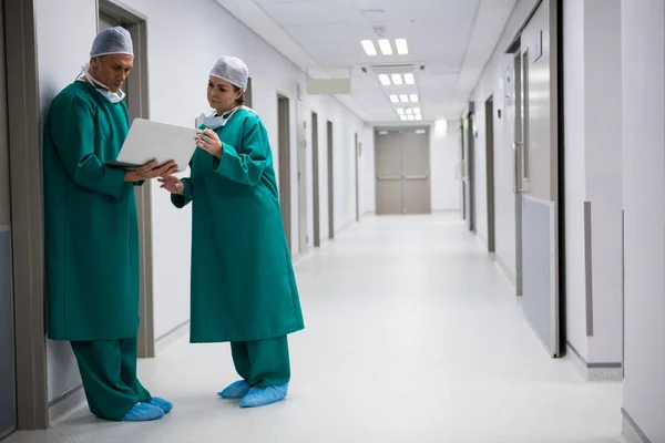 Cirurgiões usando laptop no corredor — Fotografia de Stock