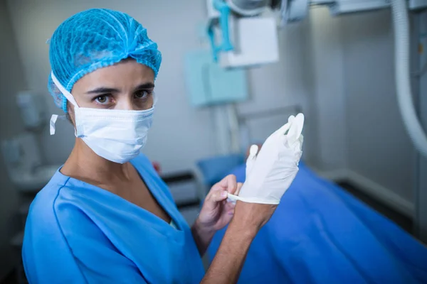 Enfermeira usando luvas cirúrgicas na sala de raios-X — Fotografia de Stock