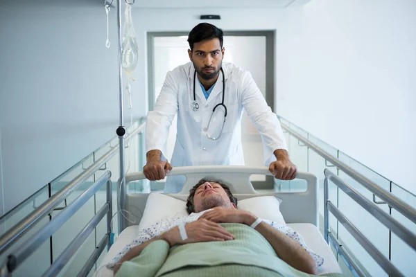 Médico empurrando cama maca de emergência — Fotografia de Stock