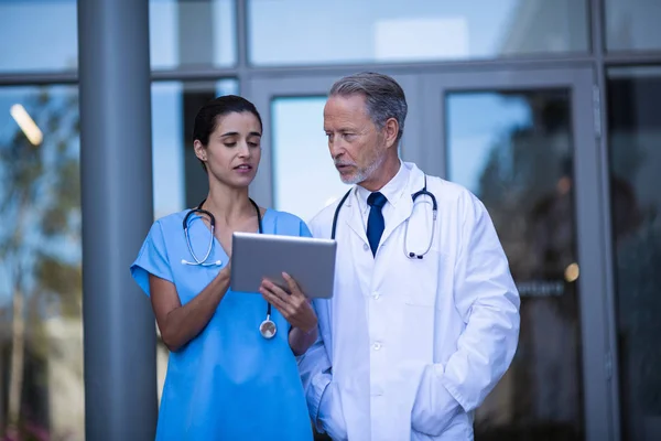 Lékař a zdravotní sestra diskutovat přes tablet — Stock fotografie