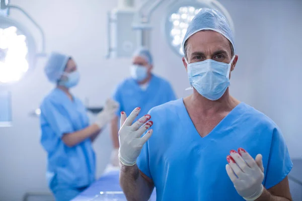 Surgeon with blood on surgical glove — Stock Photo, Image