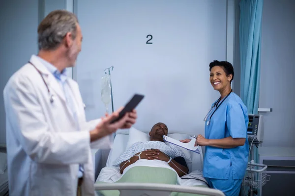 Médico interactuando con la enfermera en la sala —  Fotos de Stock