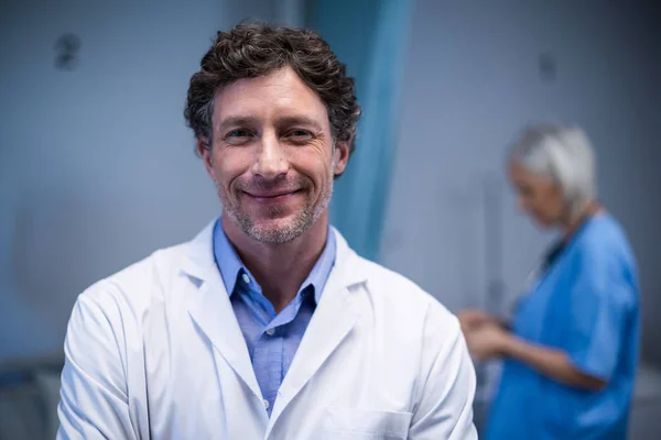 Médico sonriente parado en el hospital — Foto de Stock