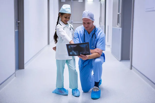 Menina sorridente e médico olhando para raio-x — Fotografia de Stock