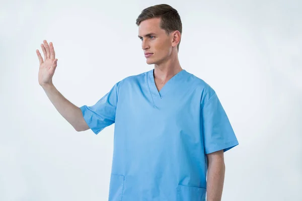 Male nurse touching an invisible screen — Stock Photo, Image