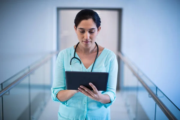 Médico femenino usando tableta digital en pasillo — Foto de Stock