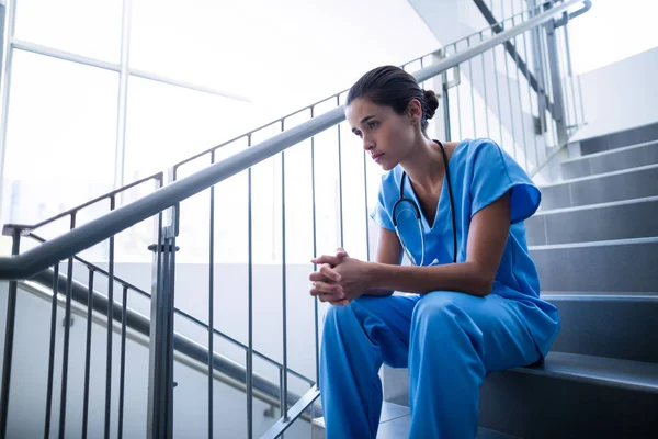 Boos vrouwelijke chirurg zittend op de trap — Stockfoto