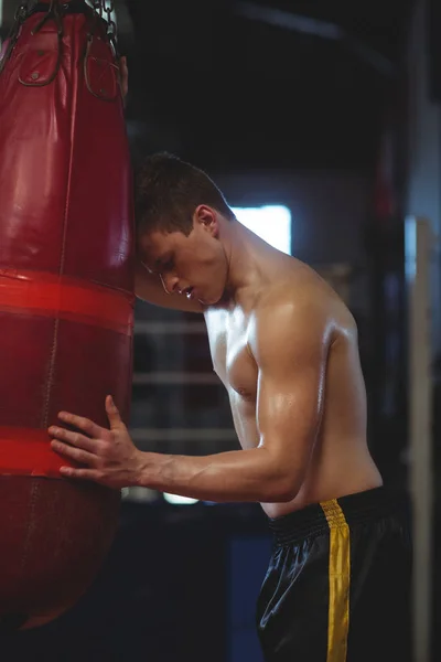 Boxer fatigué appuyé sur un sac de boxe — Photo