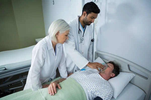 Médico colocando uma máscara de oxigênio no rosto do paciente — Fotografia de Stock