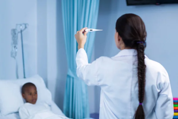 Kvinnliga läkare kontrollera feber från termometer — Stockfoto