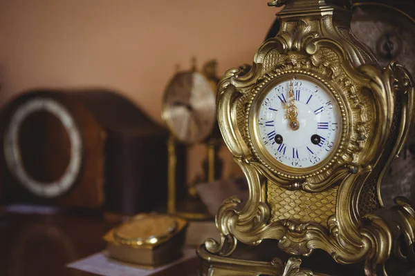 Золотые часы на столе — стоковое фото