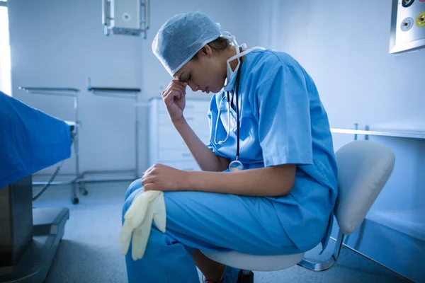 Депрессивный хирург сидит на стуле — стоковое фото