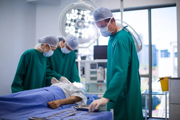 Cirurgiões realizando operação na sala de operação — Fotografia de Stock