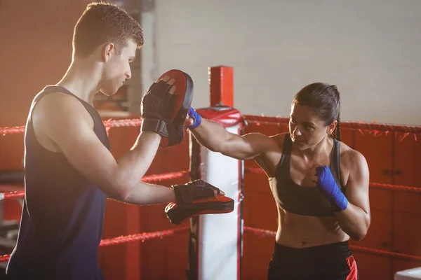 Female boxer practicing with trainer in the ring — Stock Photo, Image