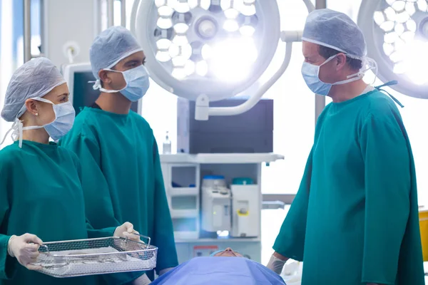 Cirurgiões interagindo durante a realização da operação — Fotografia de Stock