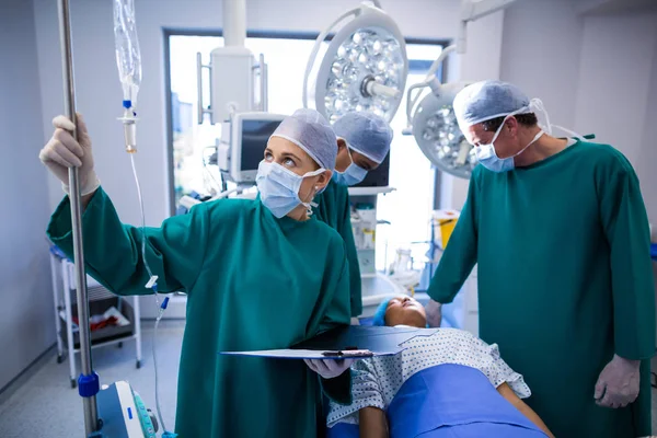 Female surgeons adjusting iv drip — Stock Photo, Image