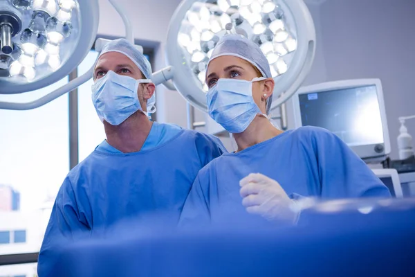 Cirurgião feminino e masculino usando máscara cirúrgica — Fotografia de Stock