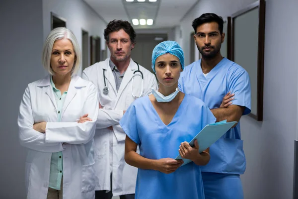 Surgeons and doctor standing in corridor — Stock Photo, Image