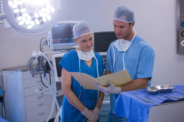 Male and female nurse having discussion over file — Stock Photo, Image