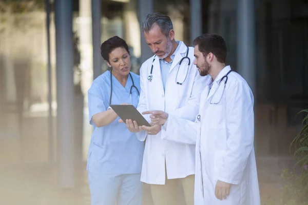 Surgeons and nurse having discussion on tablet — Stock Photo, Image