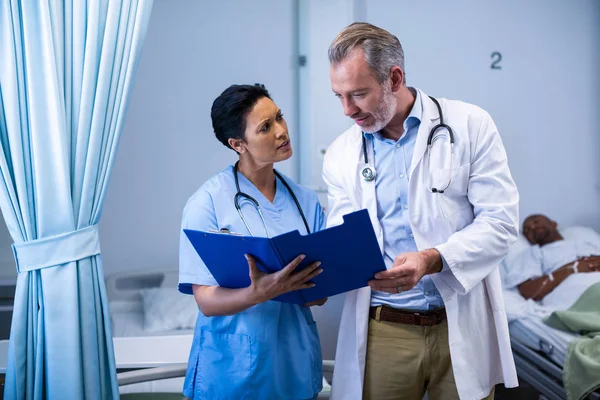 Médico y enfermera discutiendo en archivo en sala — Foto de Stock